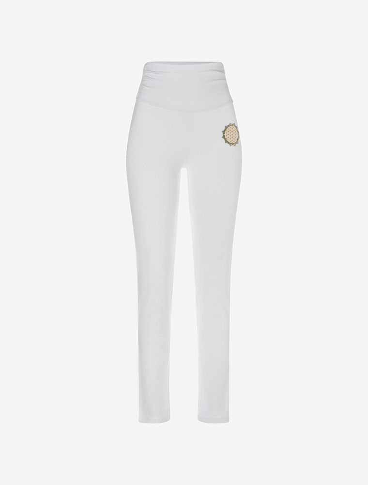 Cheerful woman with step forward in folded hands. Elegant white yoga pants with folded waistband and black bamboo top to it.