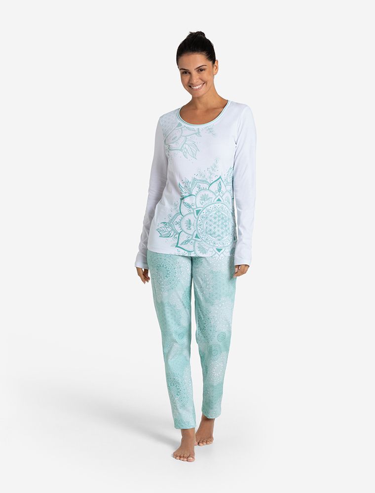 Frau in einem Pyjama-Longsleeve, Oberteil in weiß mit türkisen Mandalas und Blume des Lebens. Nachhaltig und fair aus Bio-Baumwolle produziert. Rosenquarz im Material. Hergestellt von Spirit of OM. Mit passender Hose. 
