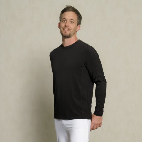 Langarm Shirt Bambus in schwarz. Mann mit Kopf leicht in den Nacken gelegt in Dreiviertelansicht. Kombination mit der Wellnesshose aus Baumwolle in weiß.